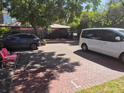 a white van and a car parked in a driveway at Pine House - self-catering in Cape Town