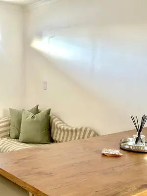 a living room with a couch and a wooden table at Lalla Cottages - Cape Town in Cape Town