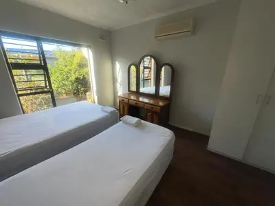 a bedroom with two beds and a desk and a window at triplediz in Blackheath
