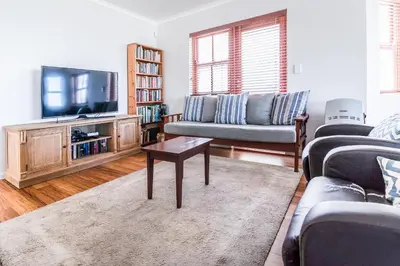 a living room with a couch and a tv at Geheim Luxury Seafront in Hermanus