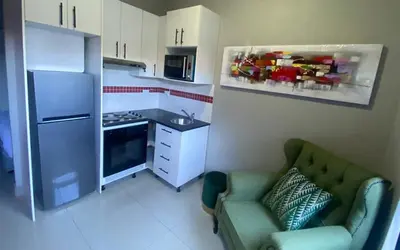 a kitchen with a green couch and a refrigerator at JM B&B - Mandalay in Mandalay