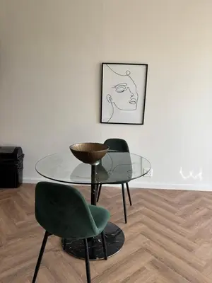 a glass table and two green chairs in a room at Modern Luxe On Park in Cape Town
