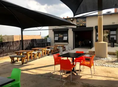 a group of tables and chairs under an umbrella at Guided Tour of Belhar South Africa in Belhar