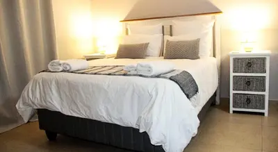 a bedroom with a large bed with towels on it at Firehouse selfcatering Garden Cottage no 2 in Wellington