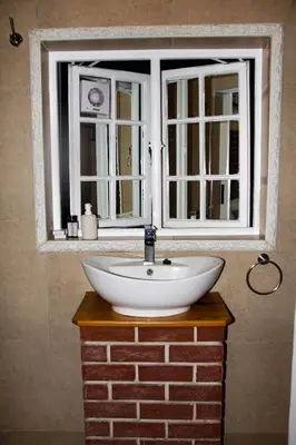 a white sink in front of a window at Firehouse selfcatering Garden Cottage no 2 in Wellington