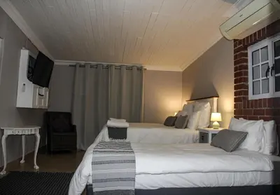 a hotel room with two beds and a tv at Firehouse selfcatering Garden Cottage no 2 in Wellington