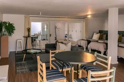a living room with a table and a couch at Mimosa Voelklip Retreat in Hermanus