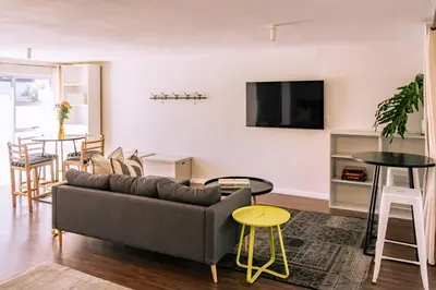 a living room with a couch and a table at Mimosa Voelklip Retreat in Hermanus
