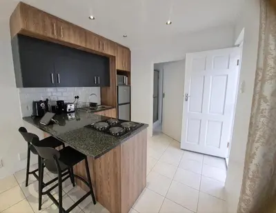 a kitchen with a island with a counter top at Oasis - Renovated - Queen extra length bed apartment in Cape Town