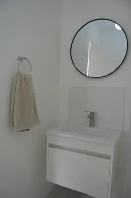 a bathroom with a mirror and a white sink at Oasis - Renovated - Queen extra length bed apartment in Cape Town
