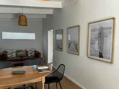 a living room with a table and a couch at BEACHees - cute central cottage in Kleinmond