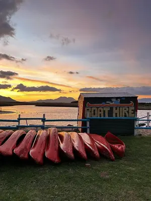 a row of red kayaks sitting next to a sign at BEACHees - cute central cottage in Kleinmond