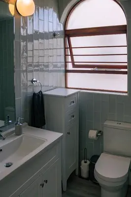 a bathroom with a sink and a toilet and a window at Voëlklip Family House in Hermanus