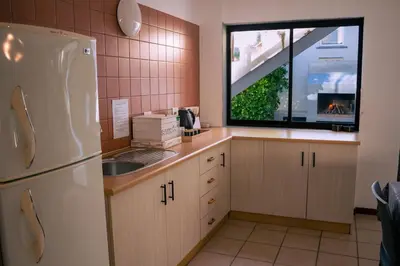 a kitchen with a white refrigerator and a window at Voëlklip Family House in Hermanus
