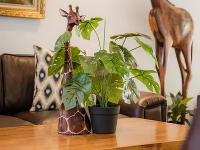 a table with two plants and a deer in the background at Cape Joy - BRAND NEW luxury villa just rolled out in Cape Town, Plattekloof in Plattekloof