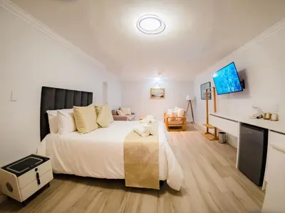 a bedroom with a large bed and a desk at Cape Joy - BRAND NEW luxury villa just rolled out in Cape Town, Plattekloof in Plattekloof