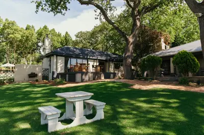 a house with a picnic bench in the yard at Le Pommier Wine Estate in Stellenbosch