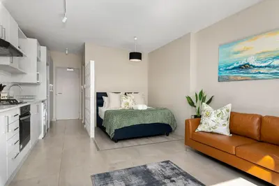 a living room with a bed and a couch at Breeze of the Sea Apartment in Cape Town