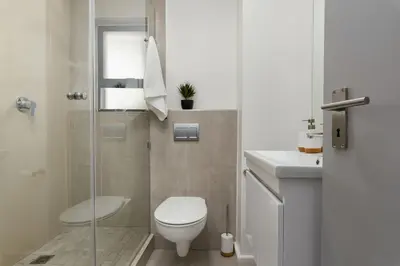 a small bathroom with a toilet and a sink at Breeze of the Sea Apartment in Cape Town