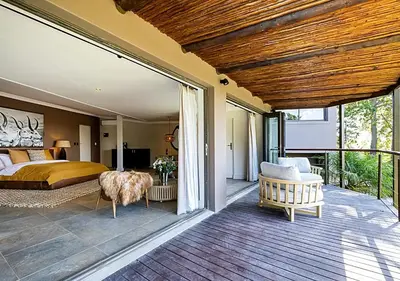 a master bedroom with a bed and a balcony at Von Wyn Berg in Stellenbosch