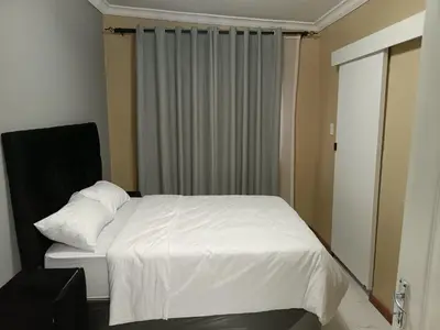 a bedroom with a white bed and a window at Spring forth guest house in De Grendel