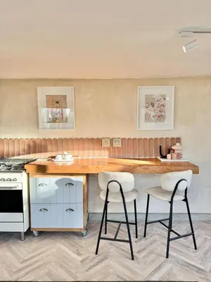 a kitchen with a wooden table and two bar stools at Grande Casa - Central Stellenbosch in Stellenbosch