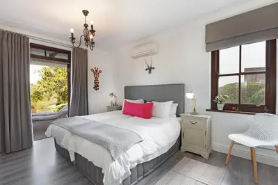 a bedroom with a large bed and a window at Winelands Golf Lodges 1 in Onder-Papegaaiberg