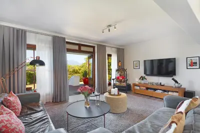 a living room with a couch and a tv at Winelands Golf Lodges 1 in Onder-Papegaaiberg