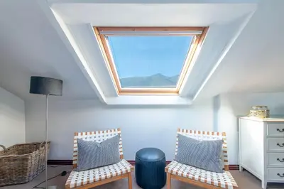 a attic room with two chairs and a skylight at Franschhoek Homestead Manor House in Franschhoek