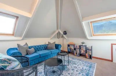 a living room with a blue couch and a table at Franschhoek Homestead Manor House in Franschhoek