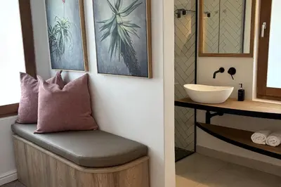 a stool in a bathroom next to a sink at Franschhoek Homestead Manor House in Franschhoek