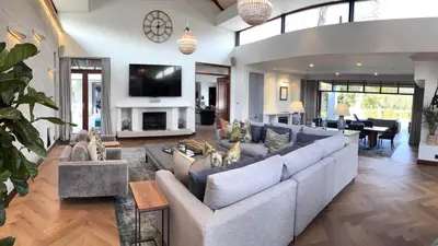 a living room with a couch and a tv at Franschhoek Homestead Manor House in Franschhoek