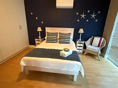 a bedroom with a bed with stars on the wall at Barking Beach Cottage, Sandbaai - Pet Friendly in Hermanus