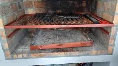 aanding grill in a brick oven with a rack at Sozo - our place at the ocean in Gordonʼs Bay