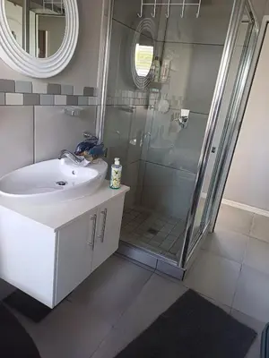 a bathroom with a sink and a shower at Sozo - our place at the ocean in Gordonʼs Bay
