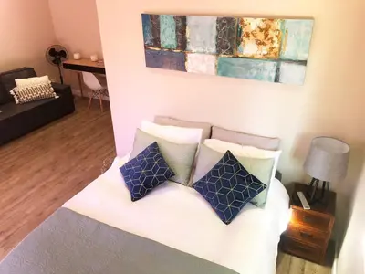 a living room with a bed with pillows on it at Modern, Comfy Guest Suite with Beautiful Views in Welgemoed in Tygerberg Hills