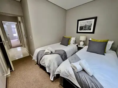 a bedroom with two beds and a window at Stay at Andringa Walk Luxury Apartment in Stellenbosch