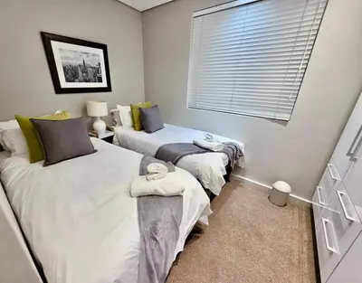 a bedroom with two beds and a window at Stay at Andringa Walk Luxury Apartment in Stellenbosch