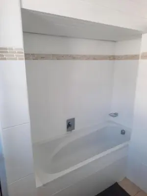 a bath tub in a bathroom with a white wall at Pips Place 203 in Strand
