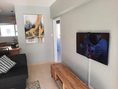 a living room with a tv hanging on a wall at Pips Place 203 in Strand