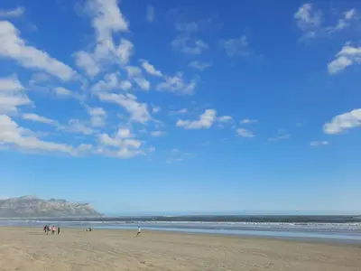 a group of people standing on a beach at Pips Place 203 in Strand