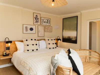 a bedroom with a large bed with white sheets and pillows at Little Villa by Ideas Cartel in Hermanus