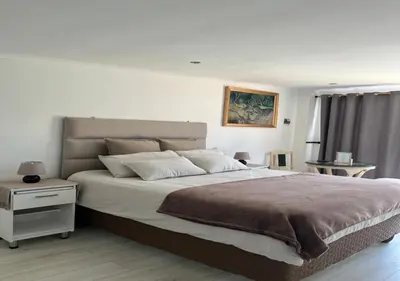 a bedroom with a large bed and a night stand at Modern Studio with Pool, 5 mins from Beach in Cape Town