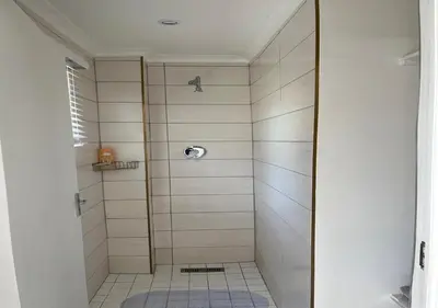 a shower with a glass door in a bathroom at Modern Studio with Pool, 5 mins from Beach in Cape Town