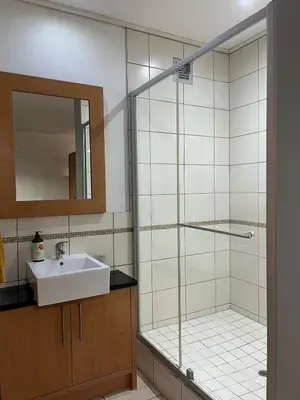 a bathroom with a shower and a sink and a mirror at Century City Studio with Table Mountain Views in Cape Town