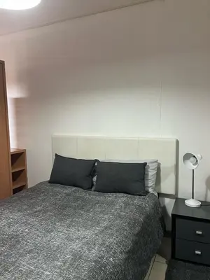 a bedroom with a bed and a white wall at Century City Studio with Table Mountain Views in Cape Town