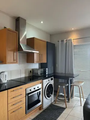 a kitchen with a washer and dryer in it at Century City Studio with Table Mountain Views in Cape Town