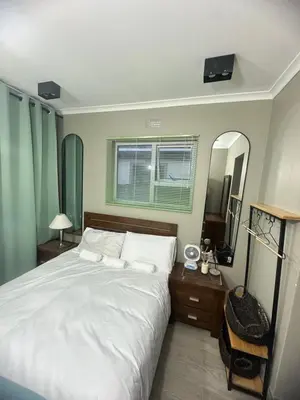 a bedroom with a large bed and a mirror at 29Windsor in Silver Sands