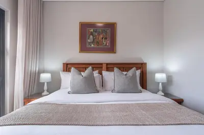 a bedroom with a large white bed with pillows at Oceanfront Escape with mountain views in Hermanus