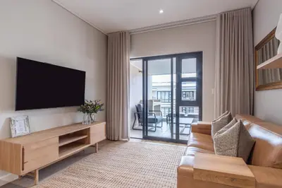 a living room with a television and a couch at Oceanfront Escape with mountain views in Hermanus